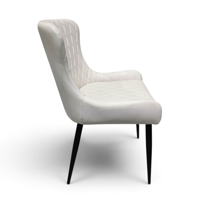 Direct Furniture Depot Miami white dining chair with diamond-pattern stitching and slim black metal legs, side view